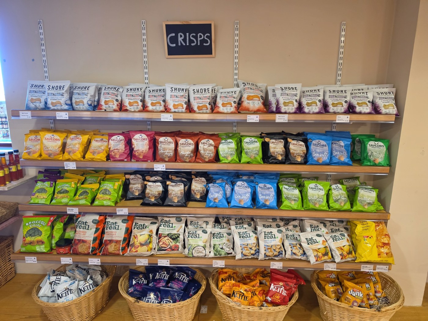 Crisps and savoury snacks arranged on wooden shelves at Jamesfield